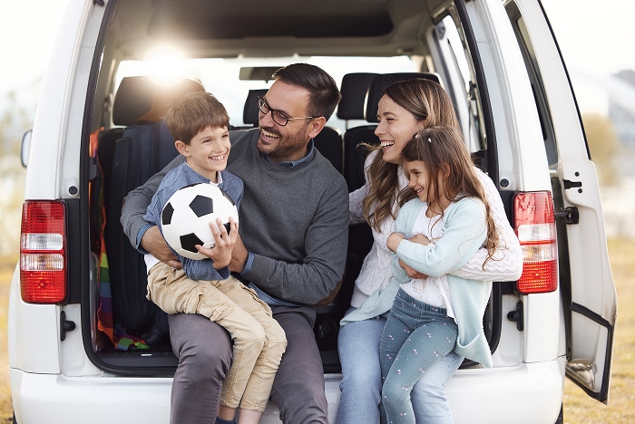 Family of four sitting in back of van