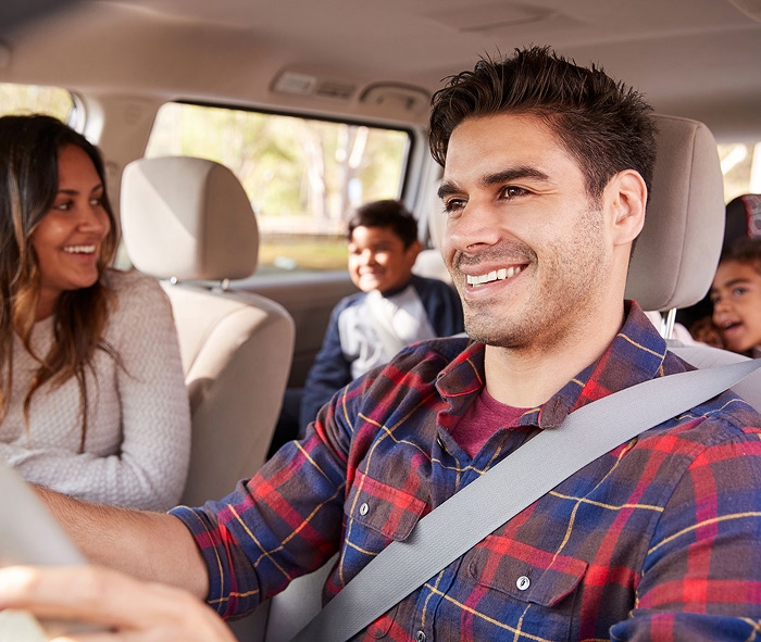 Smiling family of four in a car
