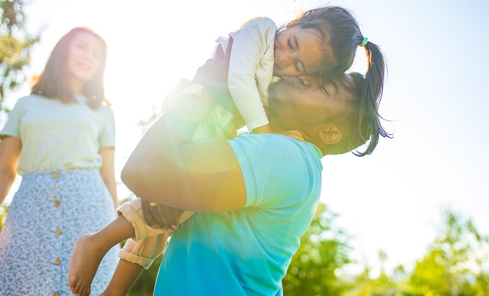Father carrying daughter with mom